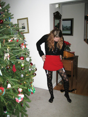 wife posing next to christmas tree